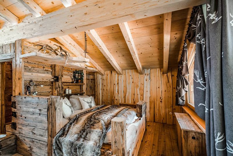Das Schlafzimmer im Obergeschoss mit rustikalem Doppelbett