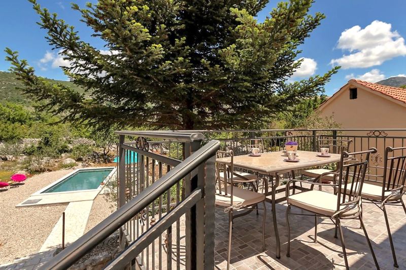 Terrasse mit Gartenmöbel und Blick auf den Pool