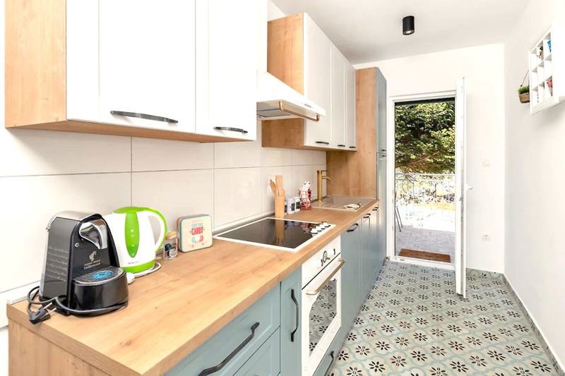 Die Küche mit Backofen und Zugang zur Terrasse