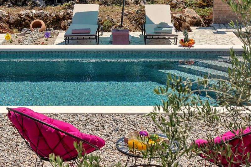 Am Pool laden Sonnenliegen und Loungemöbel zum Entspannen ein
