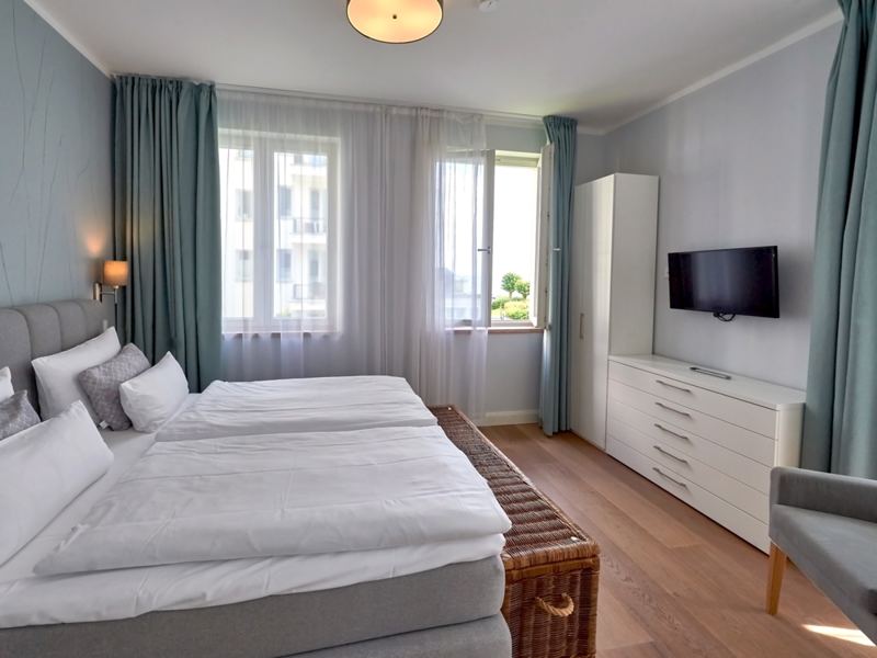 Schlafzimmer mit Doppelbett und eigenem Flachbildschirm