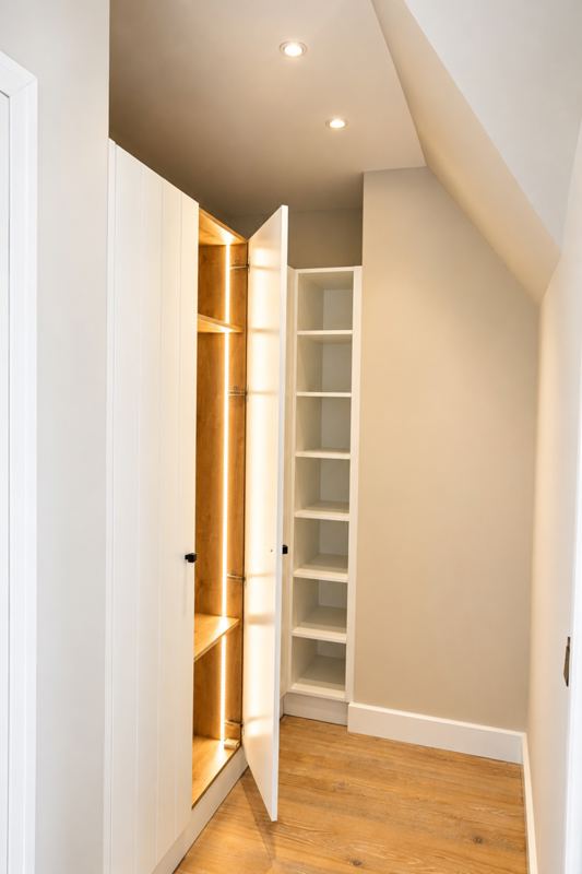 Ein separates Ankleidezimmer mit beleuchtetem Kleiderschrank 