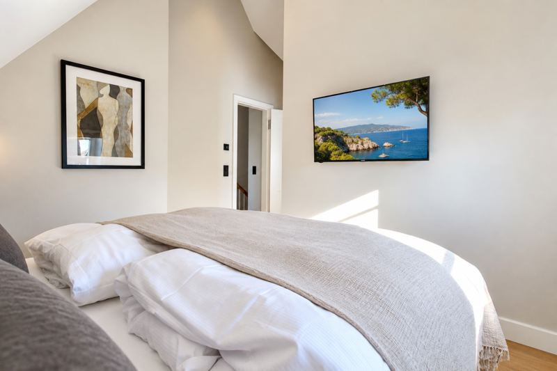 Das Schlafzimmer mit Flatscreen und separater Ankleide