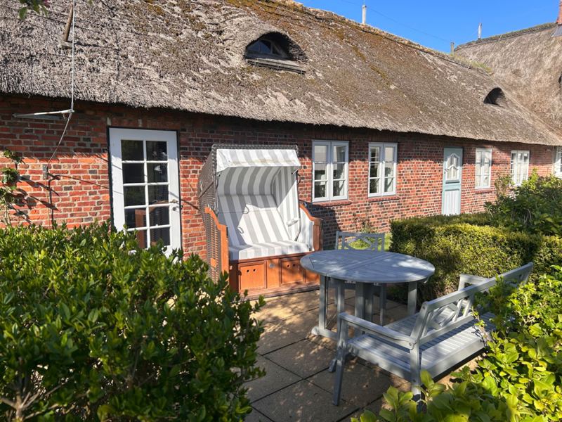Auf der Terrasse laden Gartenmöbel und Strandkorb zum Entspannen ein