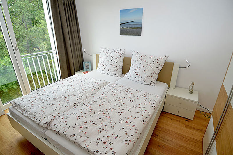 Das Schlafzimmer mit Doppelbett und Kleiderschrank