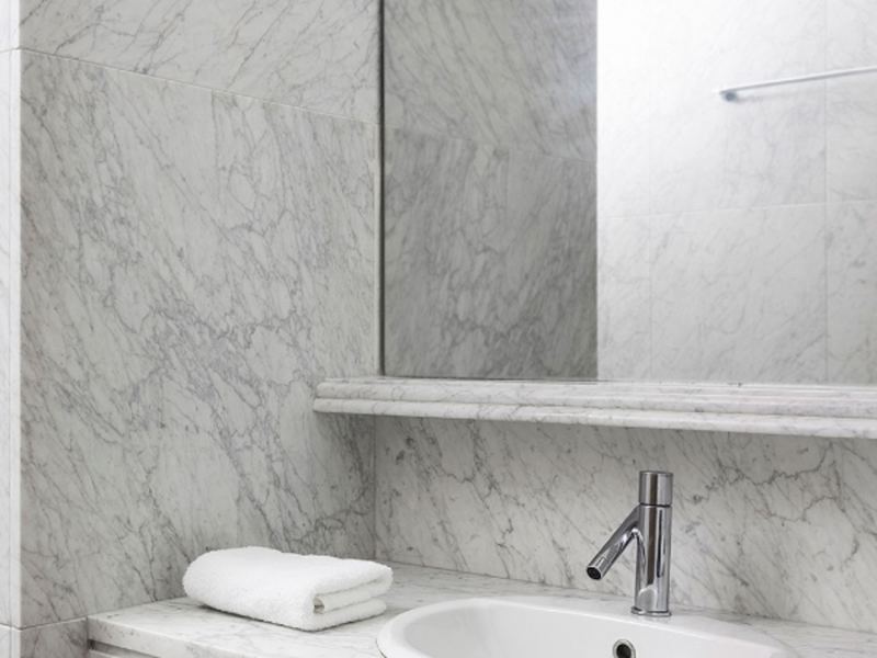 Das moderne und in weißem Marmor verkleidete Badezimmer.